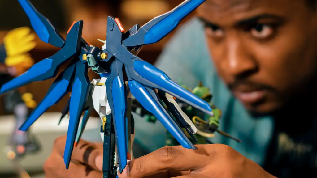 Tim Martin-Toussaint focuses intently on assembling a blue Gundam plastic model kit during a Gunpla class at RESOBOX in New York's East Village