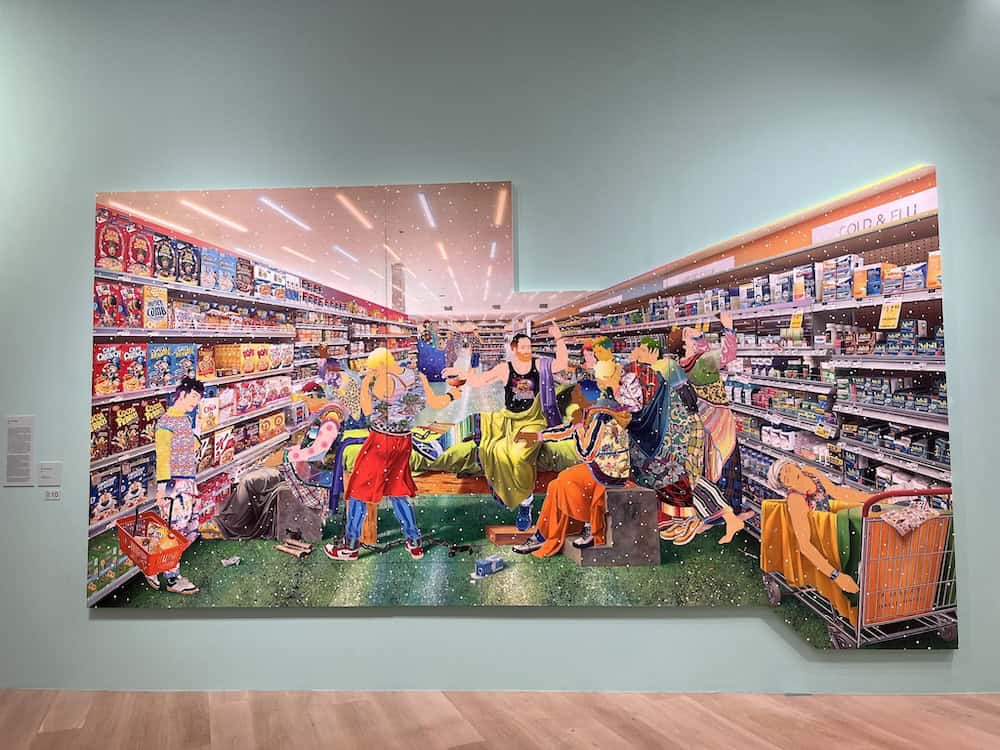 Large-scale contemporary art installation depicting vibrant supermarket scene with colorful figures shopping and socializing, pop art style painting by Japanese artist Tomokazu Matsuyama displayed in modern gallery space