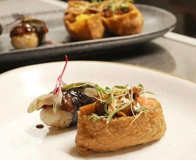 Fine dining plate featuring crispy fried shiitake preparation, braised mushroom accompaniment, and elegant microgreen garnish demonstrating Japanese mushroom culinary innovation at Third Kingdom restaurant