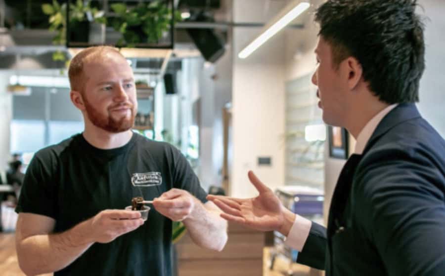 A RESOBOX market entry consultant presenting a Japanese food product to a New York business contact — supporting Japanese companies in expanding to the US market
