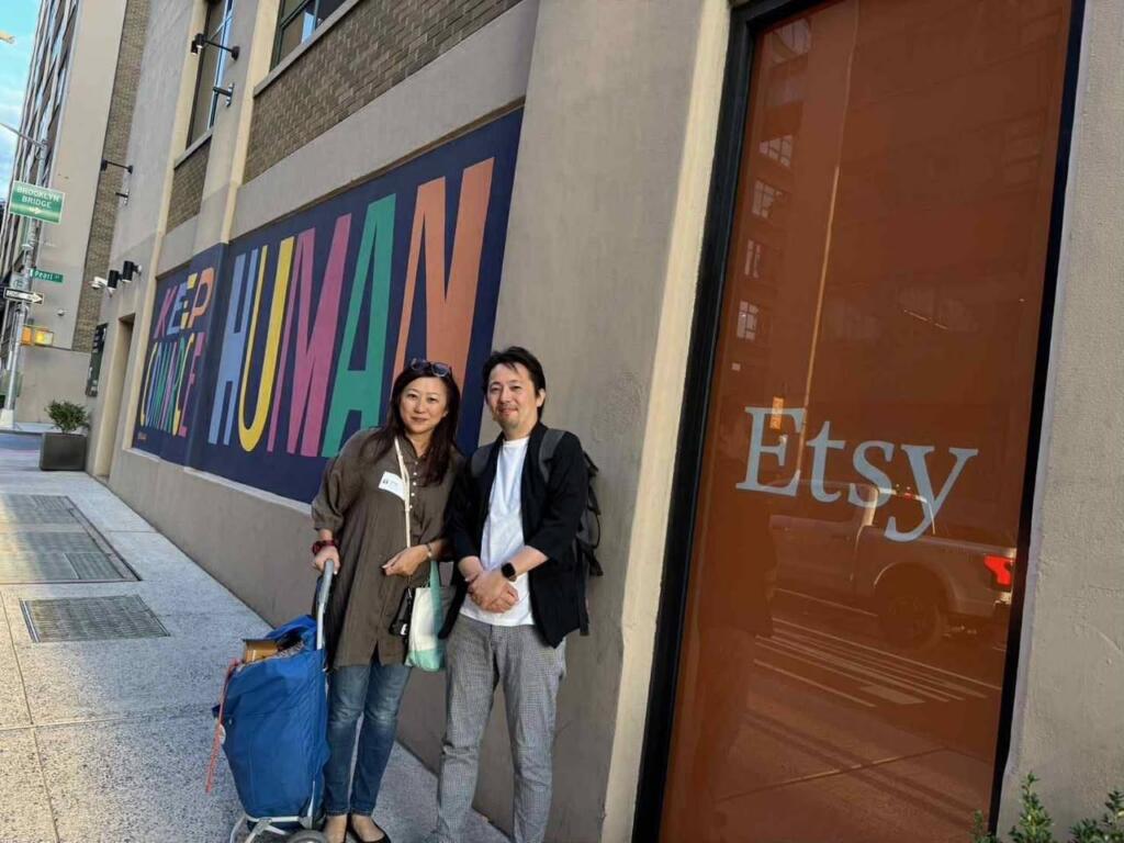 Instructor Hiroyo Belmonte and Takashi Ikezawa in front of the Keep Commerce Human mural at Etsy's Brooklyn headquarters