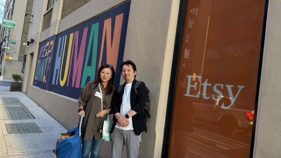 Instructor Hiroyo Belmonte and Takashi Ikezawa in front of the Keep Commerce Human mural at Etsy's Brooklyn headquarters