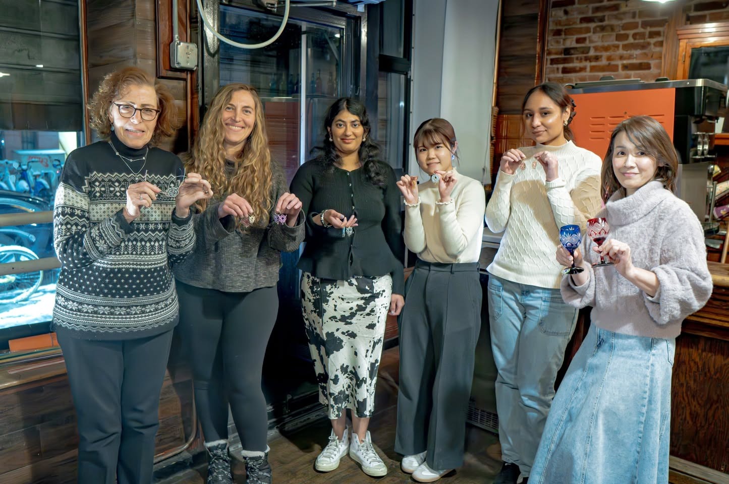 Students holding their finished mizuhiki works at the RESOBOX mizuhiki class