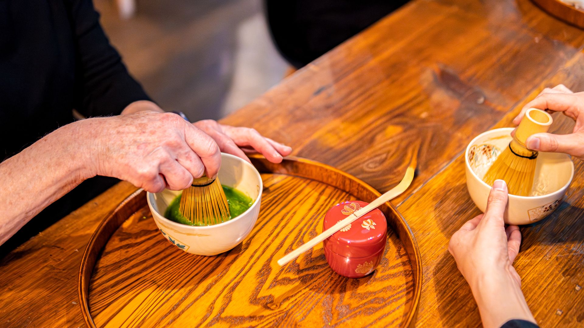 Hands whisking a bowl of matcha at a RESOBOX tea class