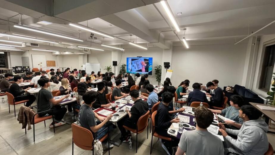 Around sixty participants painting sumi-e at a corporate workshop in a Manhattan office