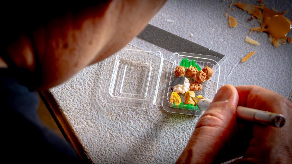 Shaping miniature onigiri, karaage and tamagoyaki inside a tiny bento container at the RESOBOX workshop