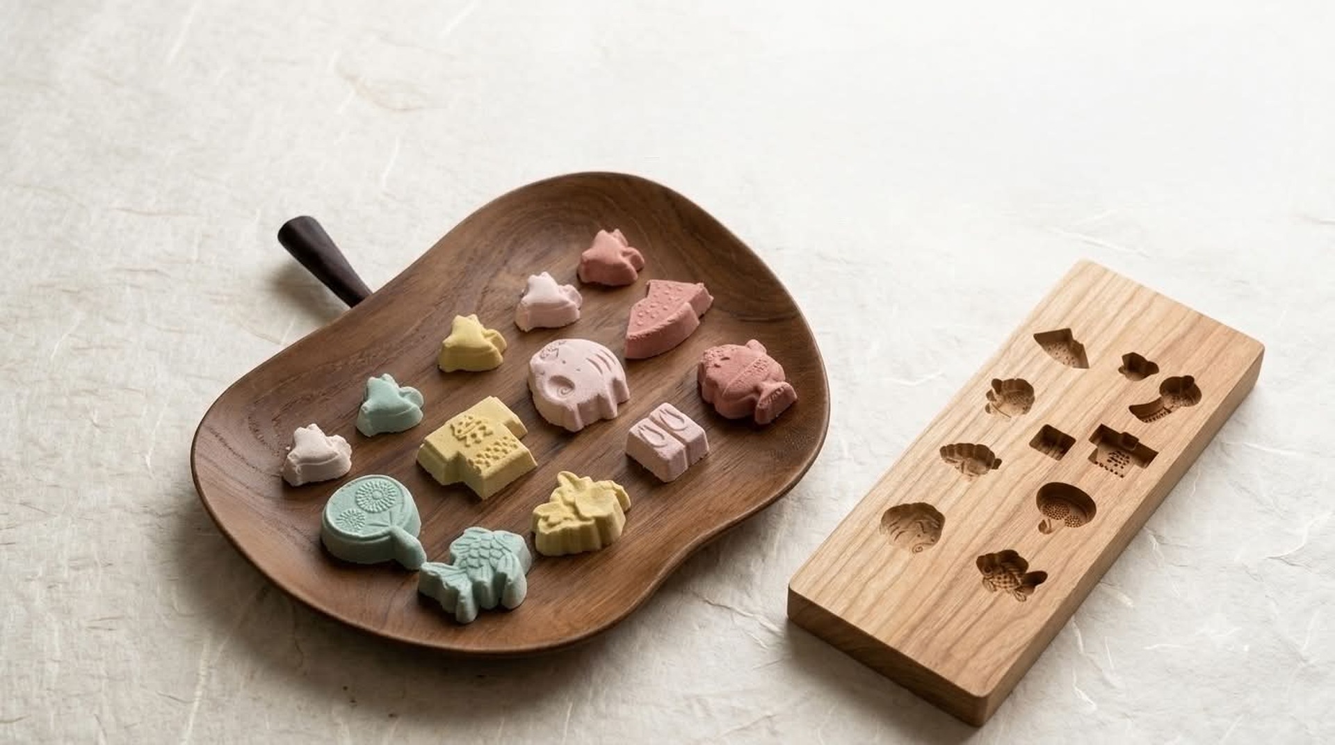 Wasanbon Wagashi Class Wasanbon pressed-sugar sweets on a wooden tray beside a carved wooden kashigata mold