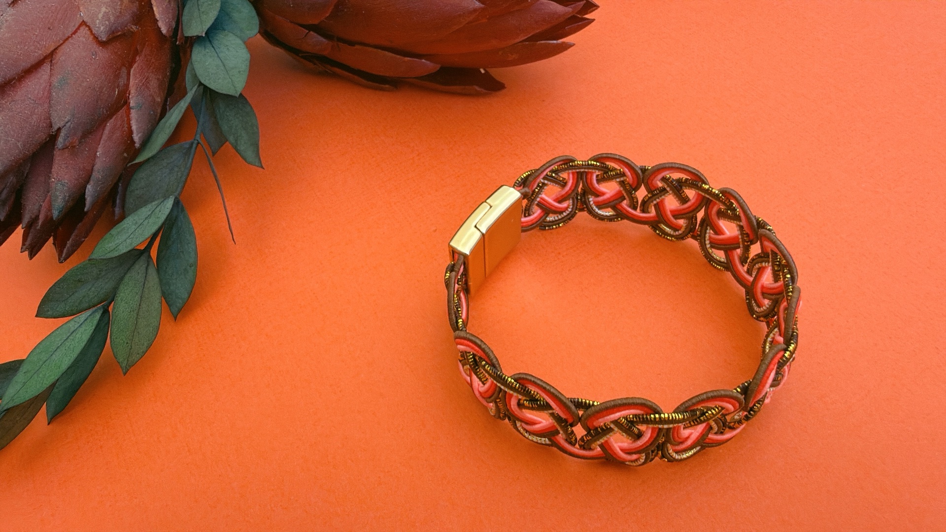 Mizuhiki woven bracelet in coral and bronze washi-paper cords