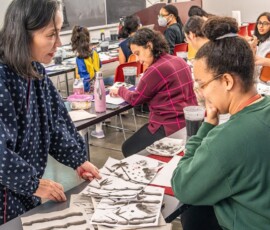 A sumi-e instructor reviewing a student's bamboo ink painting one-on-one during a Japanese ink wash painting class at Columbia University