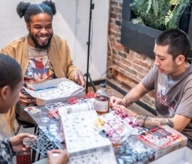 A participant focused on assembling a Japanese plastic model kit at a RESOBOX build night