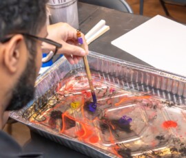 Colorful ink spreading on water surface in Suminagashi class at RESOBOX
