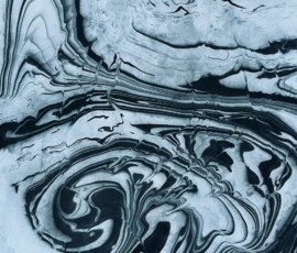 A suminagashi marbled paper print featuring a dramatic spiral vortex pattern in deep teal and black ink, created by floating ink on water