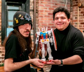 Completed and in-progress Gundam model kits displayed at a RESOBOX Gunpla workshop