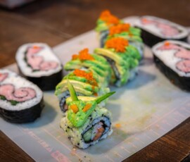 Handmade kazari maki zushi sushi rolls shaped into cartoon character faces with pink and blue colored rice, made at a decorative sushi workshop